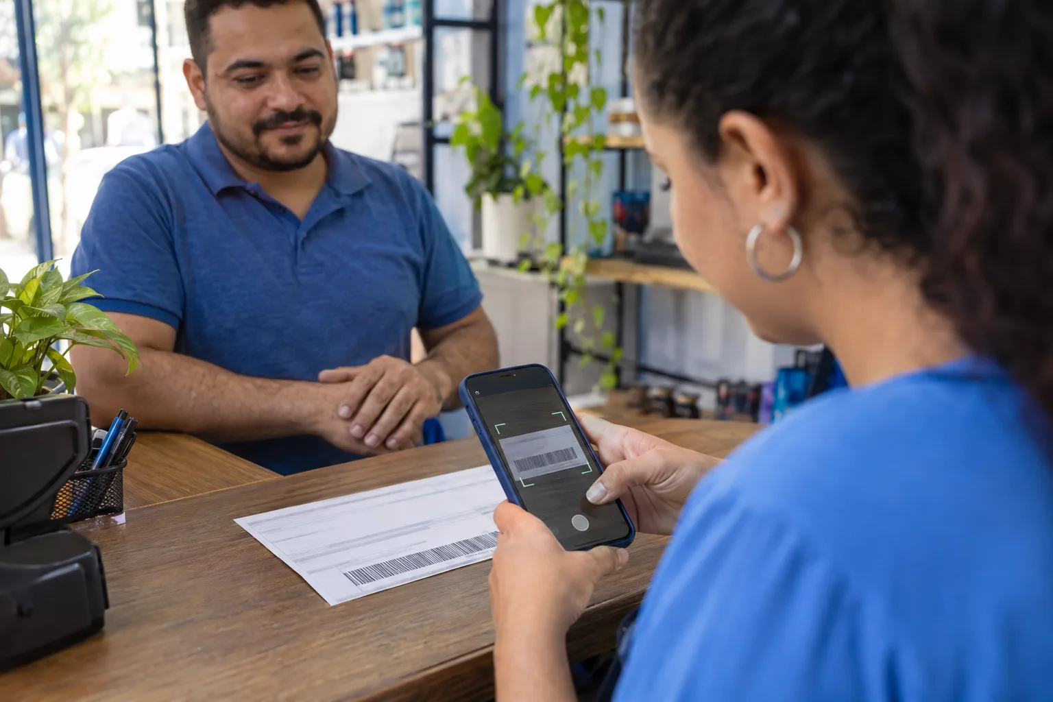 Pessoa paga uma guia escaneando o código de barras com o aplicativo do banco no celular